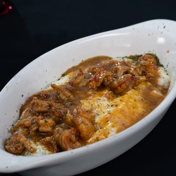 Truth Restaurant's shrimp and grits, a breakfast dish, served in a white bowl.