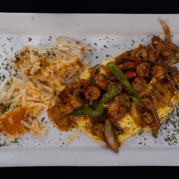 Truth Restaurant's breakfast dish featuring hash browns and a shrimp omelet with peppers and onions.
